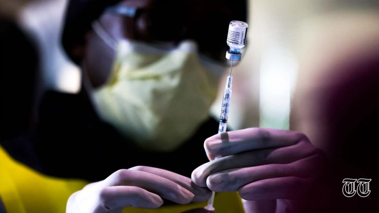 A file photo is shown of an individual preparing to administer a vaccination.