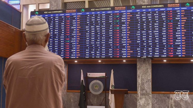 A file photo shows an individual perusing stock tickers at the PSX in Karachi.