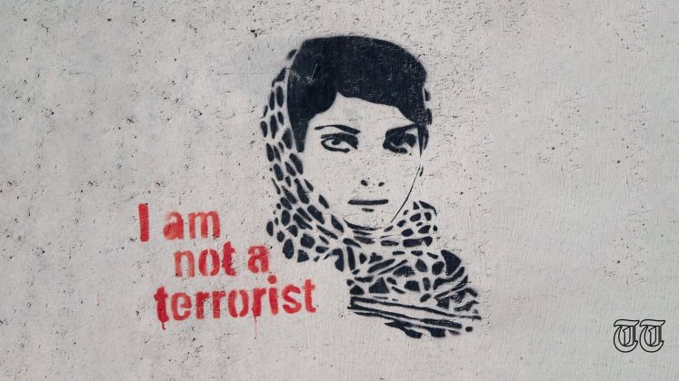 An illustration shows graffiti of a woman alongside the phrase 'I am not a terrorist.'