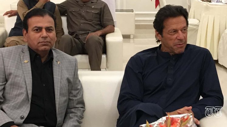 A file photo shows the writer, Ahmad Jawad, alongside former Prime Minister Imran Khan.