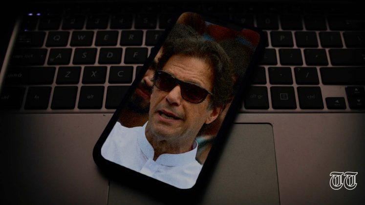 An illustration of a laptop supports a phone displaying a file photo of Prime Minister Imran Khan. — FILE/THE THURSDAY TIMES
