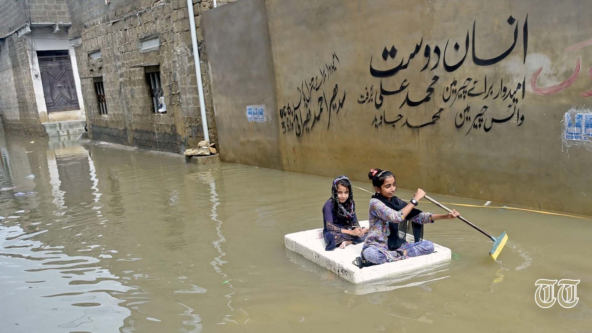 A file photo shows children using a temporary raft for transportation in Karachi.