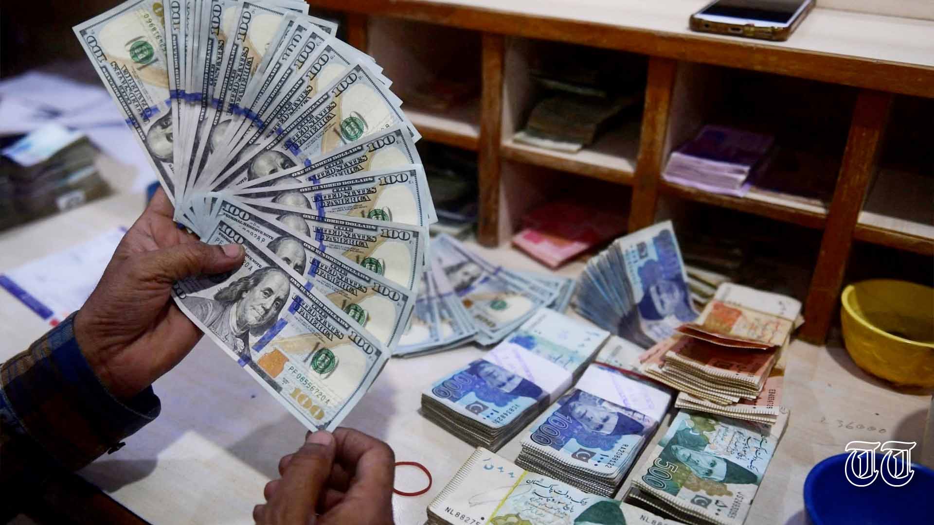 A file photo is shown of a dealer counting U.S. dollars in Karachi.