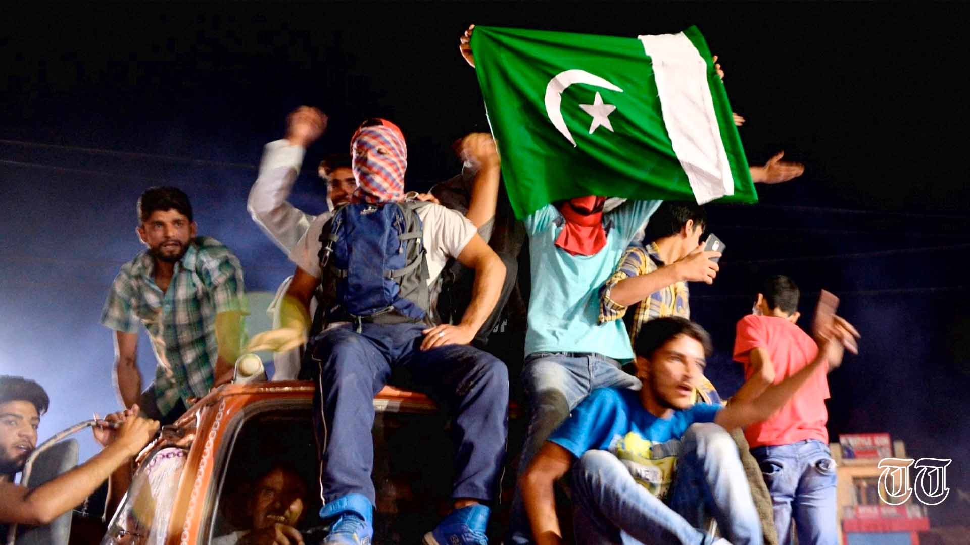 A file photo is shown of Kashmiris waving a Pakistan flag at Srinagar in 2017.