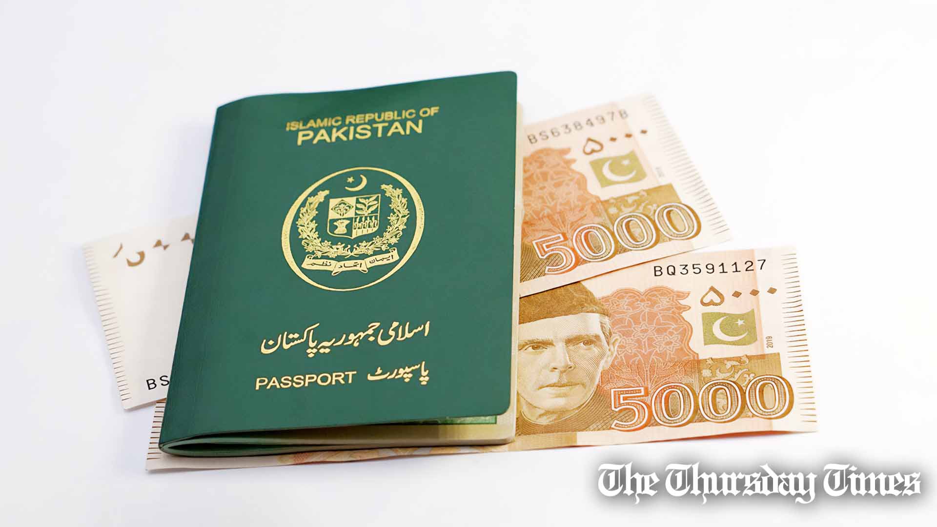 A file photo is shown of a Pakistani passport laying atop Pakistani rupees. — FILE/THE THURSDAY TIMES
