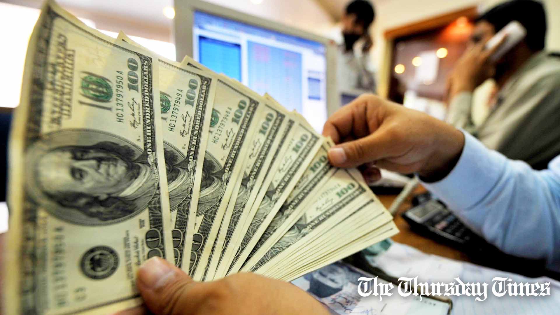 A file photo is shown of a forex dealer counting U.S. dollars at Karachi. — FILE/THE THURSDAY TIMES