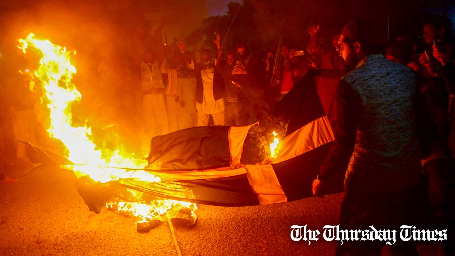 Protesters at Karachi set fire to a Swedish flag as a demonstration against the burning of the Quran in Sweden. — AFP